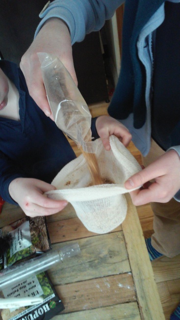 Lucy and Peter fill the sack-really a very large tea bag- with the crushed caramel grains.